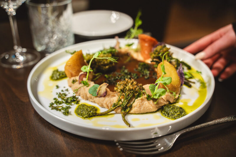 Vegetarisches Hauptgericht mit Hummus, geröstetem Bimi-Brokkoli, Kartoffeln und Kräuteröl im Landhaus Begatal